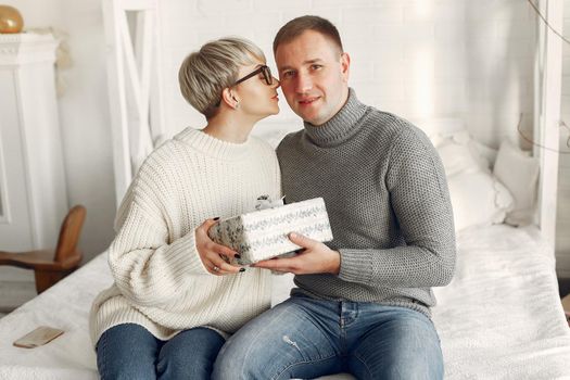 Family at home. Couple near christmas decorations. Woman in a gray sweater.