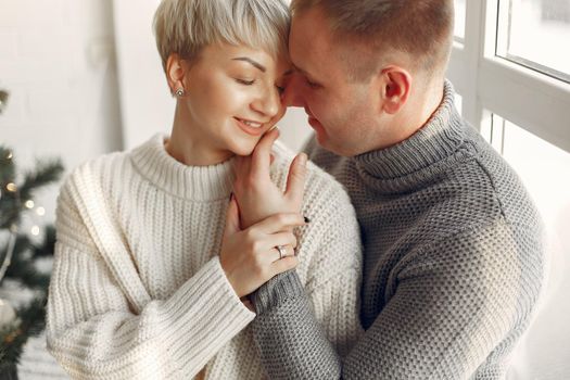 Cute couple at home. Lady in a white sweater.