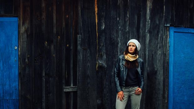 sad young woman standing near an old country house