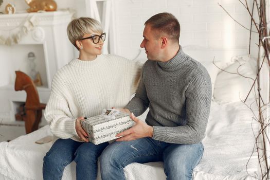 Family at home. Couple near christmas decorations. Woman in a gray sweater.