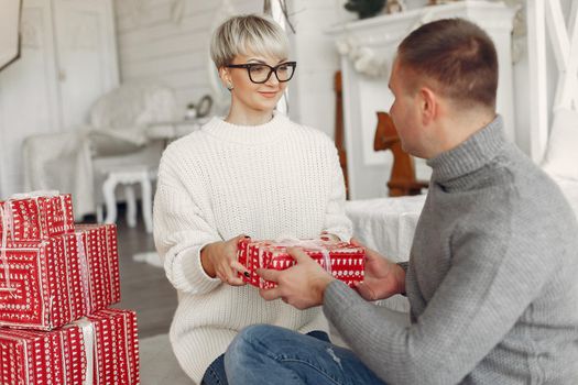 Family at home. Couple near christmas decorations. Woman in a gray sweater.