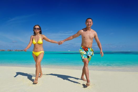 happy young asian couple have fun and romantic time at  summer on beautiful white sand beach