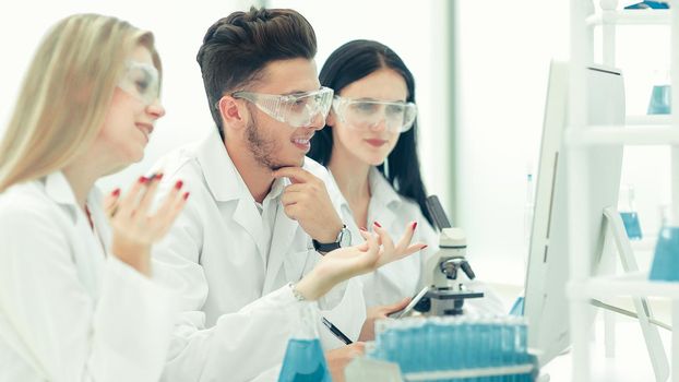 close up.a team of scientists use a computer to check the data . science and health