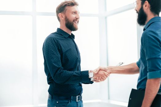 business people shaking hands in a bright office. concept of cooperation