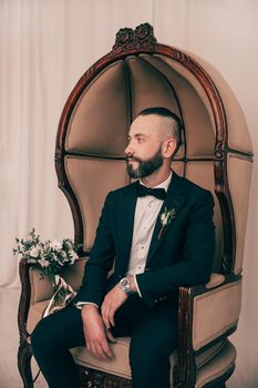 brooding groom waiting for his bride sitting in a chair . people and events