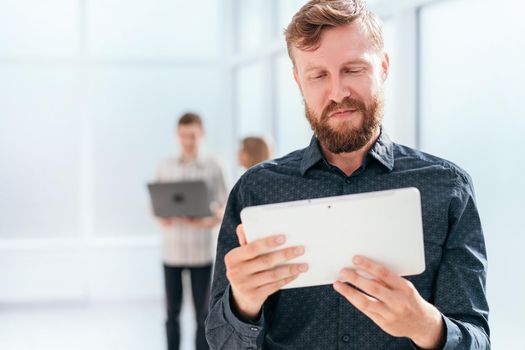 serious businessman reading message on digital tablet. photo with copy space