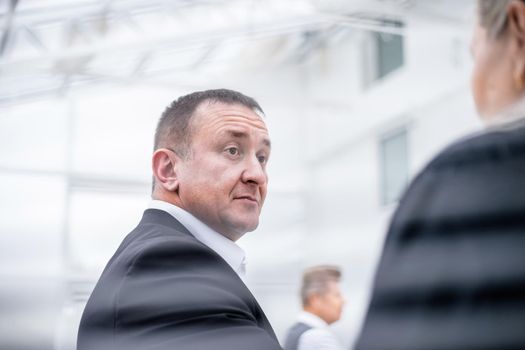 through the blinds . senior businessman standing near office window. business people