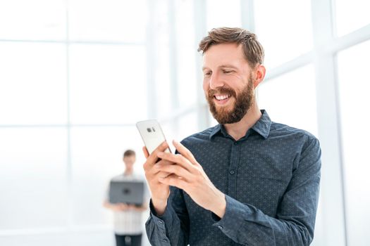 handsome businessman choosing a contact number in his smartphone. photo with copy space