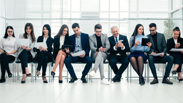 group of business people use their gadgets before starting a business meeting. photo with a copy of the space