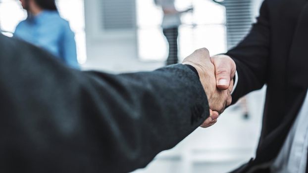 close up. handshake of business partners in the background of the office. concept of cooperation