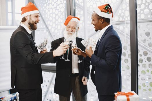 People celebrating new year. International partners. Young guys with senior man. People with champagne.