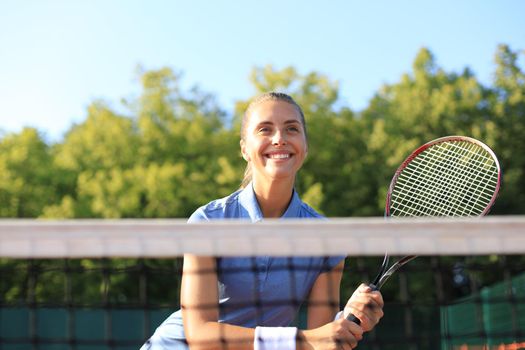 Pretty sportswoman with racquet at the tennis court. Healthy lifestyle