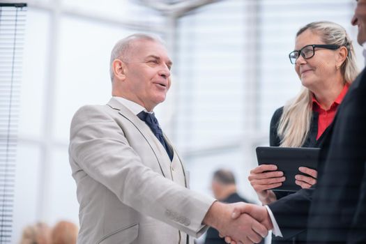 close up. confident businessman shaking hands with his business partner. business concept