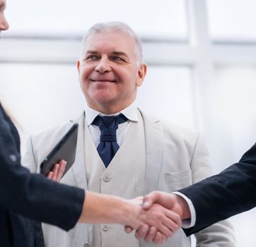 close up. smiling business people shaking hands. office weekdays