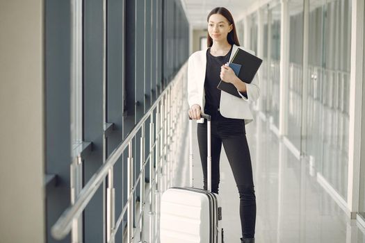 Woman at the airport. Girl with suitcase. Lady in a white jacket.