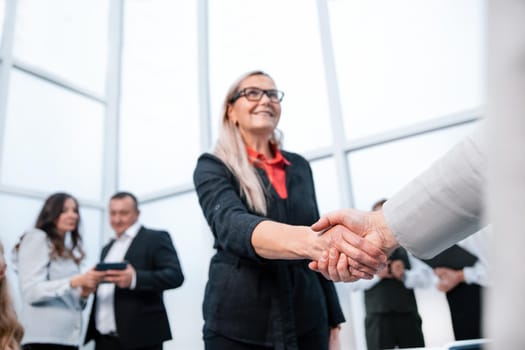 smiling businesswoman shaking hands with her business partner. the concept of cooperation