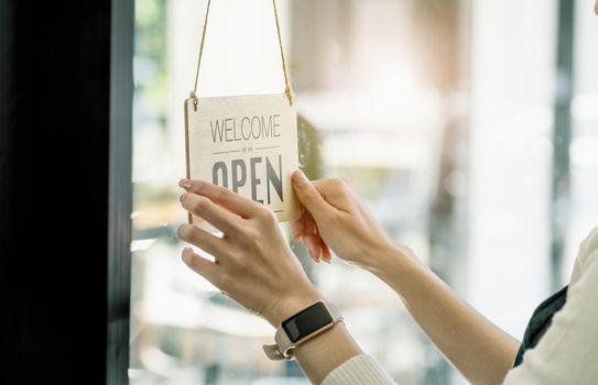 Startup stores, small business owners Standing to display a sign at the reception for customers who will come to use the service in the shop after the coronavirus situation began to unfold