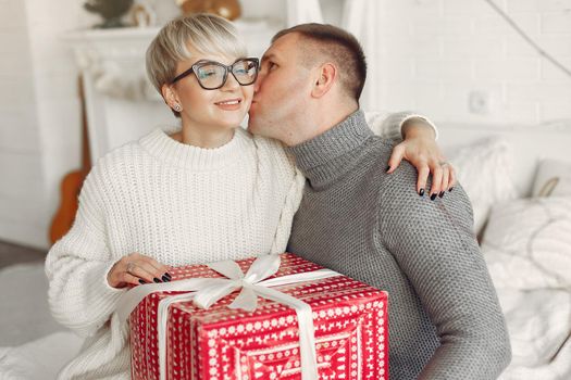 Family at home. Couple near christmas decorations. Woman in a gray sweater.