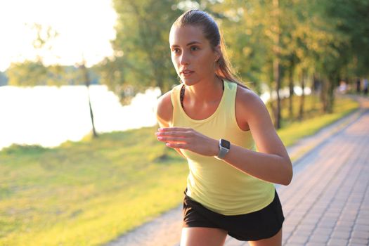 Young woman in sports clothing running while exercising outdoors