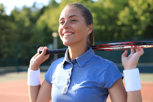 Pretty sportswoman with racquet at the tennis court. Healthy lifestyle