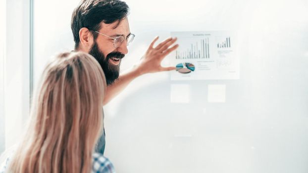 young entrepreneur pointing to a chart with financial data. photo with copy space