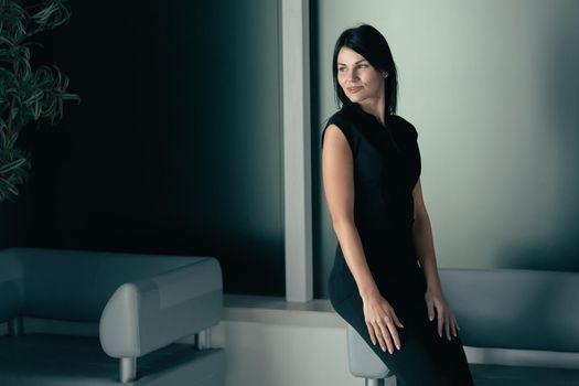 elegant business lady sitting in the office lobby. photo with a copy of the space