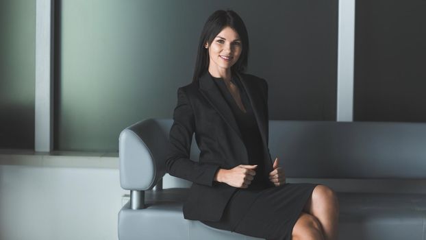 smiling business woman sitting in office lobby. photo with a copy of the space