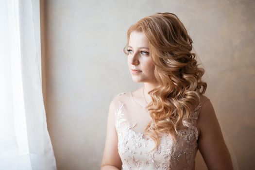 close up. young woman in wedding dress standing near the window. holidays and events