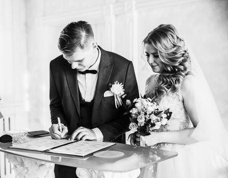 close up. the happy couple by signing a marriage contract. holidays and events
