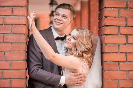 happy newlywed couple hugging each other while walking . holidays and events