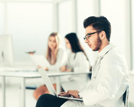 doctor works on a laptop in the hospital room .photo with copy space