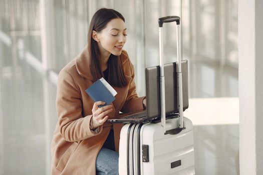 Woman at the airport. Girl with suitcase. Lady in a brown coat.