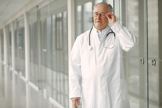 Senior in a hall. Doctor in a uniform. Man in a glasses.