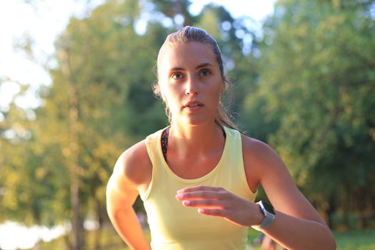 Young woman in sports clothing running while exercising outdoors