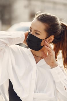 Woman in the city. Person in a mask. Coronavirus theme. Woman in a white shirt.