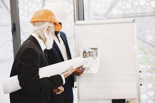 African man in a black suit. Old engineer with boss. Young guy with senior man. Writing board.