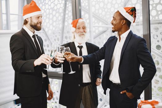 People celebrating new year. International partners. Young guys with senior man. People with champagne.