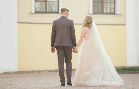 bride and groom walking down the street of the old town. holidays and events