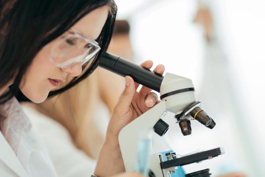 close up.the scientist looks into the microscope in the laboratory. science and health