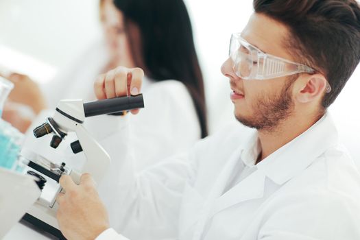 close up.man scientist looking through a microscope.science and health