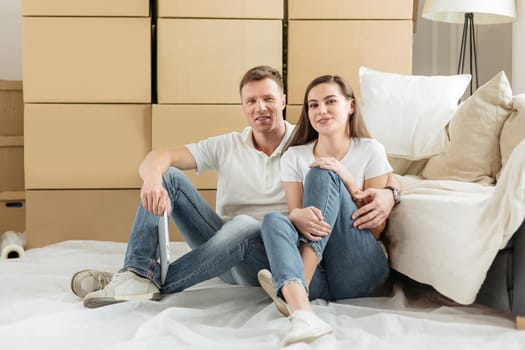 happy couple sitting near boxes in a new apartment. photo with copy-space