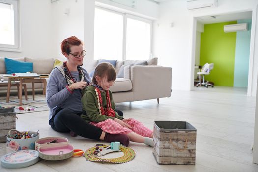 Mother and little girl daughter playing with jewelry while staying at home in coronavirus quarantine