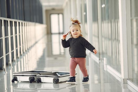 Child at the airport. Little girl with a suitcase.