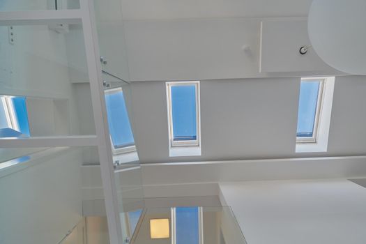 Automatic remote White skylight roof windows in a loft with white walls