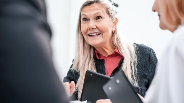 close up. smiling businesswoman talking to her colleagues. office weekdays