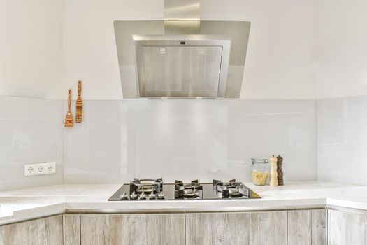 Pretty part of the kitchen with a modern gas stove and hood