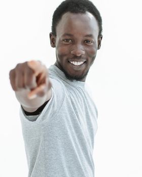 young man in a white t-shirt points at you. isolated on white background