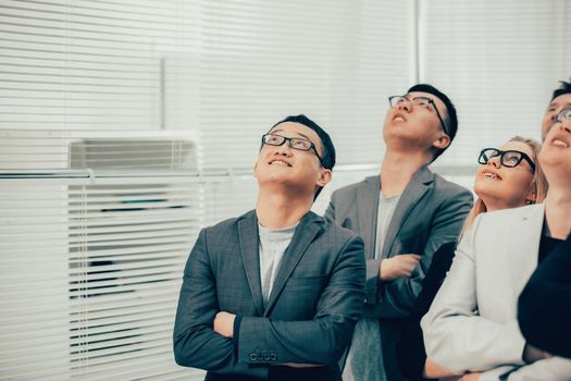 close up. a group of young business people looking up. photo with copy-space