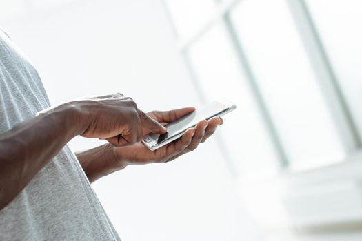 close up. young man typing SMS on his smartphone. photo with copy space