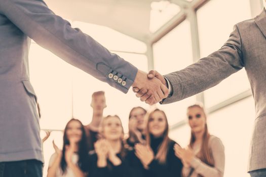 close up. confident young business people shaking hands. photo with copy space